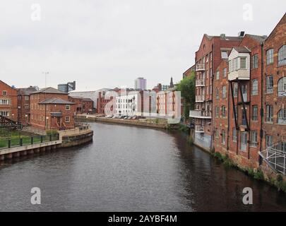 blick auf das riverside der Calls Landing Area von leeds mit Apartments und Gebäuden am Wasser, die sich im Fluss Aire widerspiegeln Stockfoto