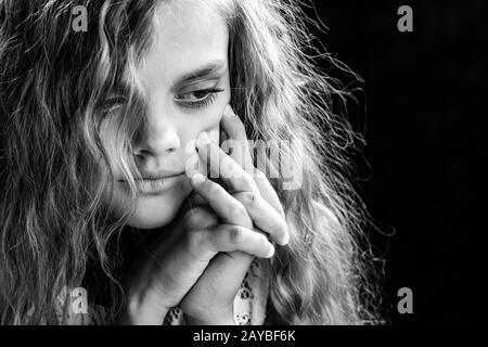 Psychologische Schwarz-Weiß-Porträt eines Mädchens auf schwarzem Hintergrund Stockfoto