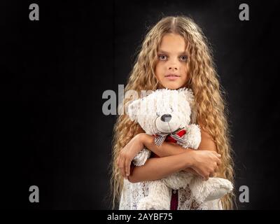 Porträt eines jungen Mädchens, Umarmungen ein altes Stofftier Bär Stockfoto