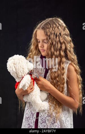Portrait von ein junges Mädchen mit einem alten Teddybär, ein Liebling der Kindheit Spielzeug Stockfoto