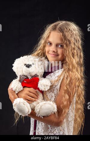 Portrait von ein junges Mädchen mit einem alten Spielzeug tragen Stockfoto