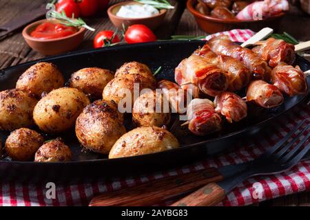 Rustikale Datteln mit Speck und junger gerösteter Kartoffel. Stockfoto