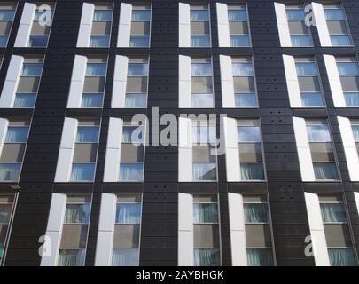 Blick auf die Fassade eines großen schwarz-weiß-modernen Geschäftshauses mit sich wiederholenden Fenstern und Stockfoto