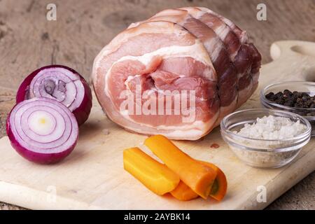 Rohes Schweinebraten auf dem Schneidebrett Stockfoto