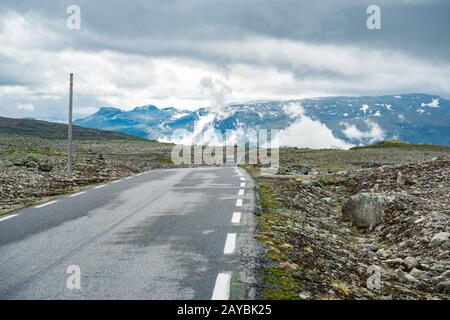 Wohnmobil in norwegischen Bergen. Urlaub und Reisen im Tourismus. Wohnwagen Wohnmobil fährt auf der Bergstraße vorbei an Norwegen. Scandi Stockfoto