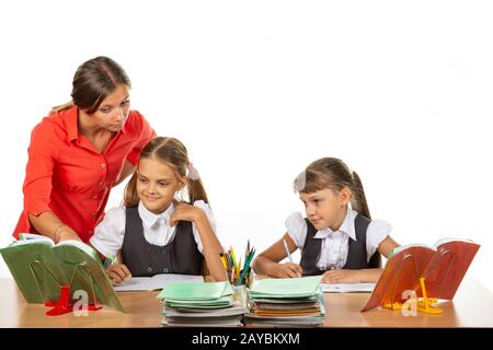 Die Lehrerin hilft die Aufgabe des Schülers zu verstehen Stockfoto