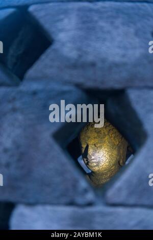 Blick auf eine Buddhastatue in einem perforierten Stupa auf der oberen Plattform des Borobudur-Tempels (UNESCO-Weltkulturerbe, neuntes Jahrhundert), dem größten B Stockfoto