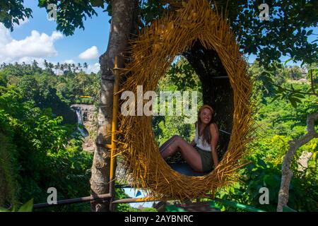Ein Tourist posiert für Fotos vor dem Tegenungan-Wasserfall (Tukad Petanu River) in der Nähe von Ubud, Bali Indonesia. Stockfoto