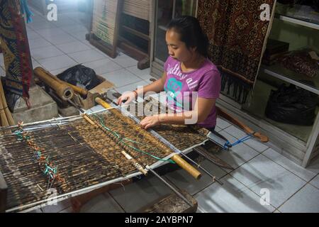 Eine Frau webt doppeltes Ikat in ihrem Haus im Dorf Tenganan in Ostbali, Indonesien. Stockfoto