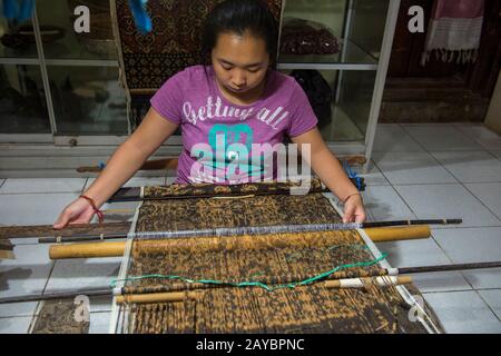 Eine Frau webt doppeltes Ikat in ihrem Haus im Dorf Tenganan in Ostbali, Indonesien. Stockfoto