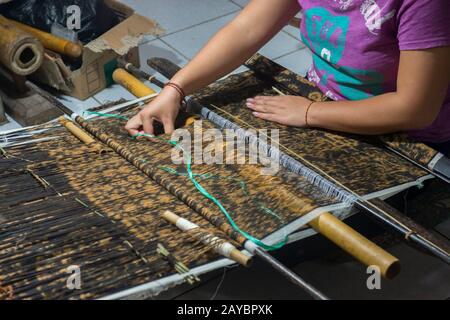 Eine Frau webt doppeltes Ikat in ihrem Haus im Dorf Tenganan in Ostbali, Indonesien. Stockfoto