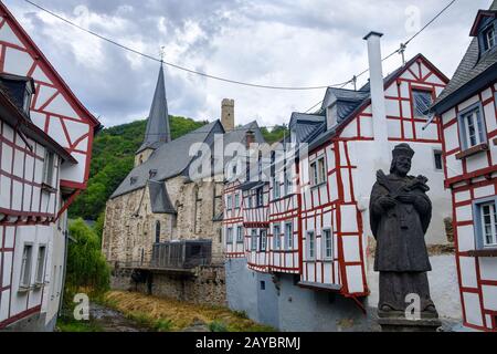 Das malerische Dorf Monreal mit der Statue Johannes von Pomuk an der Steinbrücke in der Eifel, Deutschland Stockfoto