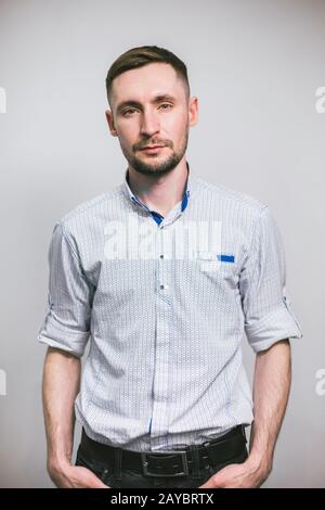 Vertrauen und Geschäftskonzept. Porträt eines fröhlichen, modischen, gutaussehenden Mannes. Porträt des jungen gutaussehenden Mannes im Hemd Stockfoto