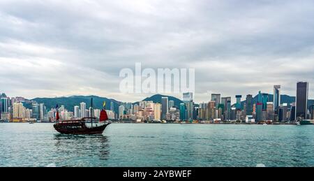 Traditionelle chinesische Dschunke Boot vor der Skyline von Hongkong Stockfoto