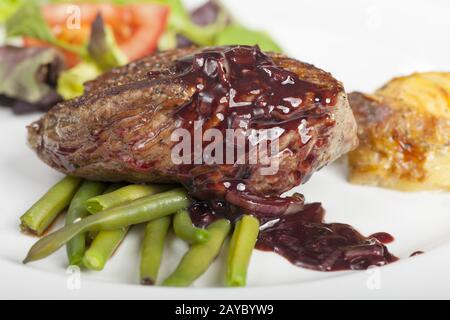 Scheiben eines Steaks auf Bohnen Stockfoto