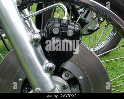 Nahaufnahme einer Metallscheibenbremse am Vorderrad eines alten Motorrads Stockfoto