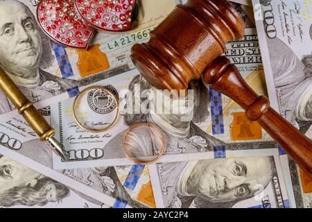 Nahaufnahme von Hochzeitsringen und Richter Gavel über das scheidungskonzept von amerikanischen Dollar-Banknoten Stockfoto