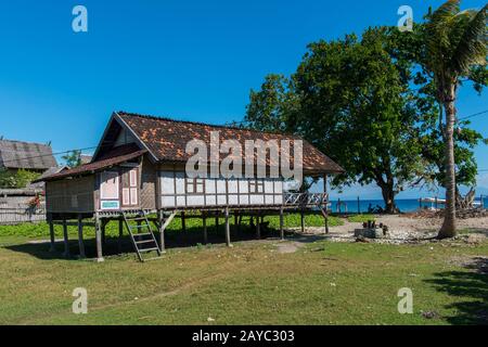 Eine Dorfszene mit einem traditionellen Haus auf Stelzen im kleinen Dorf Moyo Labuon auf Moyo Island, vor der Küste der Insel Sumbawa, Indonesien. Stockfoto