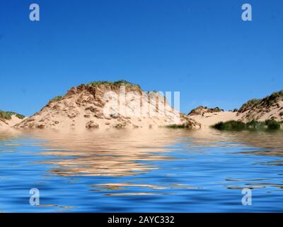 Der Strand vom Meer auf der formby merseyside mit hohen Sanddünen, die mit rauem Gras bedeckt sind, und einem blauen, sommerlichen Sonnenhimmel Stockfoto