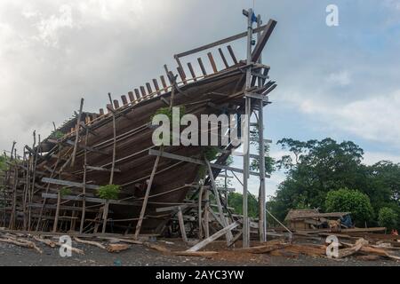 Ein sehr großes Pinisi-Boot wird am Strand in Sangean Village, Sangeang Api Volcano Island in der Nähe von Sumbawa Island, kleine Sundainseln, Indone gebaut Stockfoto