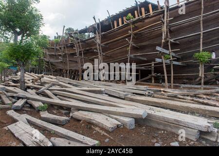 Ein sehr großes Pinisi-Boot wird am Strand in Sangean Village, Sangeang Api Volcano Island in der Nähe von Sumbawa Island, kleine Sundainseln, Indone gebaut Stockfoto