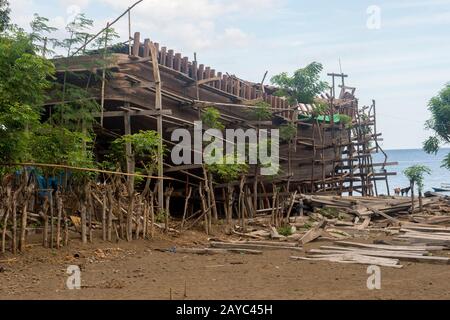 Ein sehr großes Pinisi-Boot wird am Strand in Sangean Village, Sangeang Api Volcano Island in der Nähe von Sumbawa Island, kleine Sundainseln, Indone gebaut Stockfoto