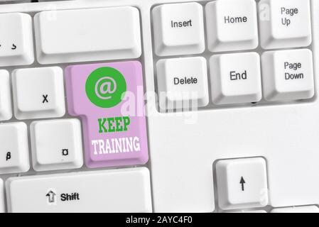 Textzeichen mit Keep Training. Konzeptfoto Bohren immer fragen Sie sich, ob Sie neugierig sind, lernen Sie die weiße pc-Tastatur mit leeren Stockfoto