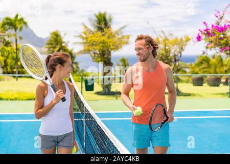 Tennisfreunde haben Spaß beim Spielen auf dem Außenplatz. Paare oder gemischte Doppel-Tennispartner im Sommer draußen. Glückliche junge Menschen, Frauen und Männer leben einen gesunden aktiven Lebensstil. Stockfoto