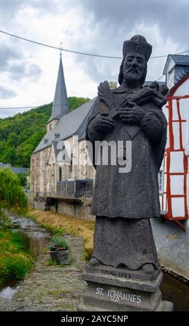 Das malerische Dorf Monreal mit der Statue Johannes von Pomuk an der Steinbrücke in der Eifel, Deutschland Stockfoto