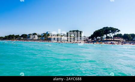 Touristen, die an einem Strand von Alcudia, Mallorca, Urlaub in der Sonne genießen Stockfoto