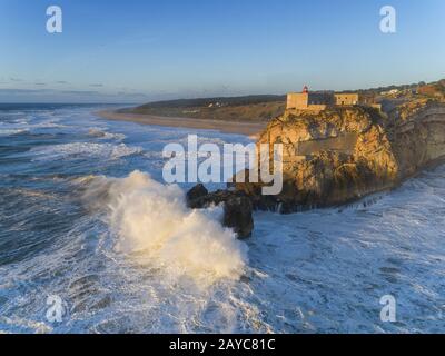 Leuchtturm und große Wellen in Nazare Stockfoto