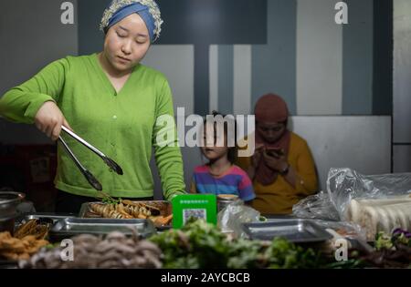 Muslimische Frau, die Lebensmittel verkauft Stockfoto