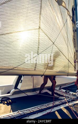 Mann auf einem Katamaranboot hinter Segel Stockfoto