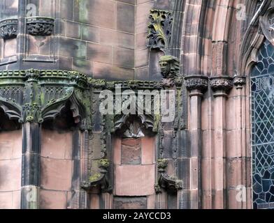 Details zu kunstvoll geschnitzten mittelalterlichen Steinmetzarbeiten mit Nischen und Gesichtern an der Fassade der chester Kathedrale Stockfoto