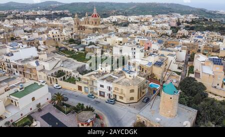 Luftbild der Stadt Xaghra in Gozo, der kleineren Insel Maltas. Die Windmühle TA'Kola und die Kirche Xaghra sind in der Ferne zu sehen Stockfoto