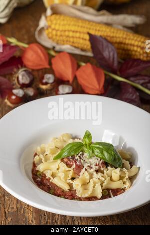 Pasta mit Tomatensauce auf dunklem Holz Stockfoto