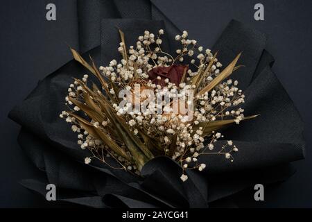 Getrocknete Rosenblume und Gypsophila mit getrockneten Blättern isoliert auf schwarzem Grund Stockfoto