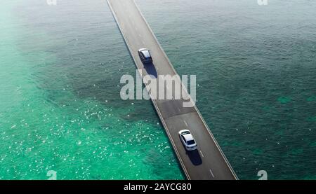 Zwei Autofahrerpasse auf der Überführung über die Brücke auf See Stockfoto