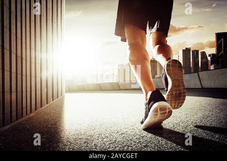 Nahaufnahme der Läuferbeine auf der Straße. Sunrise Morning Scene. Stockfoto