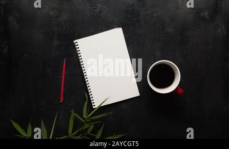 Schwarzer Schreibtisch aus Holz mit Notizbuch Stockfoto