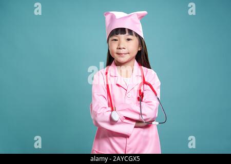 Porträt eines kleinen asiatischen Mädchen in einem Ärzte Uniform mit Stethoskop auf Vintage grüner Hintergrund isoliert. Stockfoto