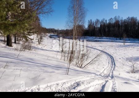 Ivanovo, Russland - 02/08/2020: Landschaft mit einem kleinen Fluss an einem sonnigen Wintertag und einem blauen wolkenlosen Himmel. Stockfoto