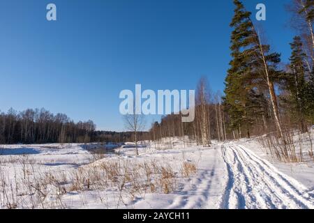 Ivanovo, Russland - 02/08/2020: Landschaft mit einem kleinen Fluss an einem sonnigen Wintertag und einem blauen wolkenlosen Himmel. Stockfoto