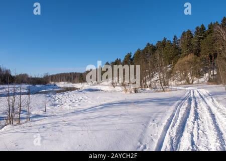 Ivanovo, Russland - 02/08/2020: Landschaft mit einem kleinen Fluss an einem sonnigen Wintertag und einem blauen wolkenlosen Himmel. Stockfoto