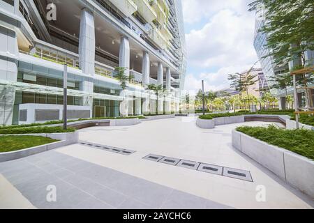 Schwachwinkeliger Blick auf das leere Straßenbelag und das moderne Bürogebäude mit umweltfreundlichem Konzept. Stockfoto