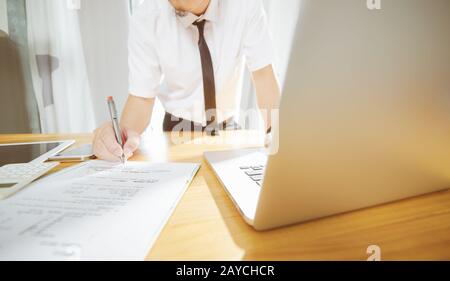 Geschäftsmann mit Laptop und treffen Sie die Entscheidung, ein großes Projekt zu unterzeichnen. Stockfoto