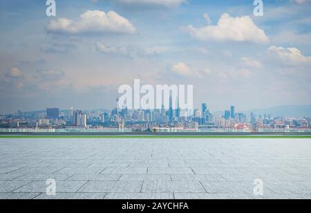 Leeres, quadratisches Erdgeschoss mit Hintergrund der Skyline der Stadt. Gemischte Medien . Stockfoto