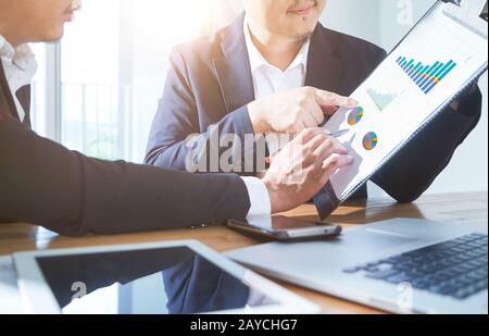 Zwei Geschäftsleute diskutieren die Diagramme und Grafiken, die die Ergebnisse ihres erfolgreichen Projekts .Digital Tablet zeigen Stockfoto