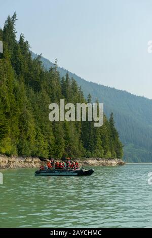 Menschen vom Kreuzfahrtschiff Safari Endeavour in einem Tauchzodiac, die Thomas Bay in der Nähe von Juneau, Tongass National Forest, Alaska, USA erkunden. Stockfoto