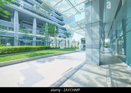 Außenansicht eines modernen Bürogebäudes aus Stahl und grünem Glas mit leerem Gehweg. Panoramaaussicht. Moderner Architekt Stockfoto